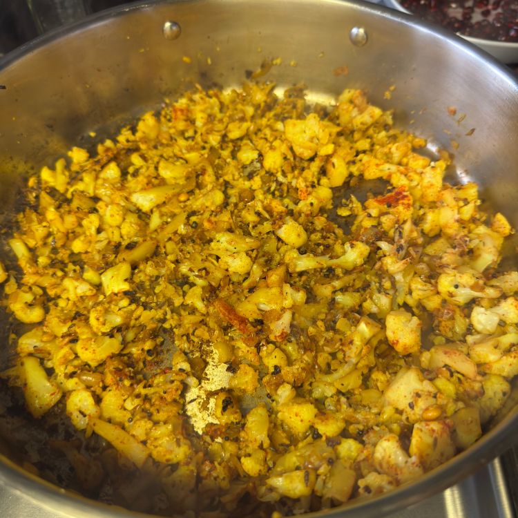 Fully cooked Cauliflower Vepudu Fry in a pan, coated with spices and ready to serve.