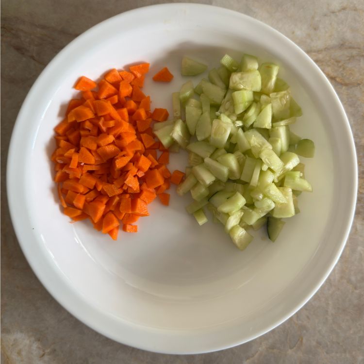 Ingredients for cucumber carrot salad in a plate