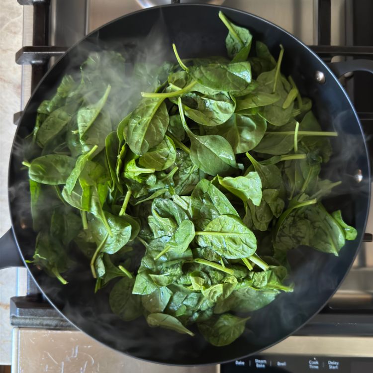 Spinach on a pan for Sauteed Spinach with Podi over stove