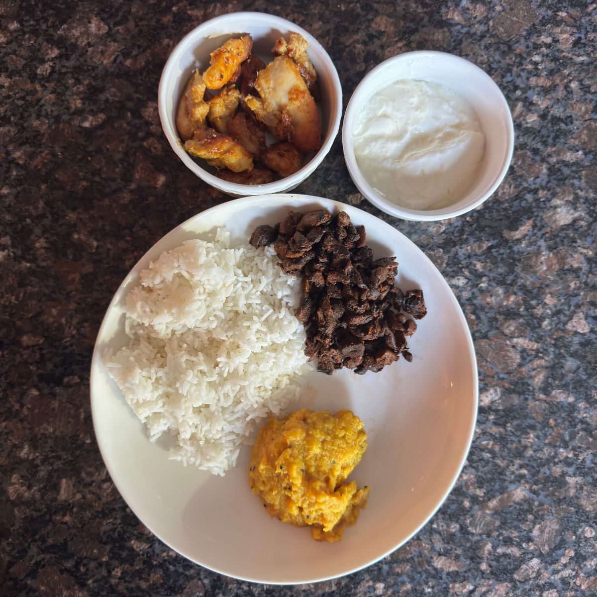 Delicious and Nutritious South Indian Tomato Pappu Thali featuring Tomato Pappu, White Rice, Oven Baked Chicken Thighs, Mushroom Fry, and Homemade Yogurt.