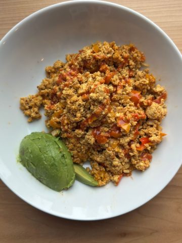 Finished Tofu Burji garnished with avocado and served hot, showing perfect scrambled texture